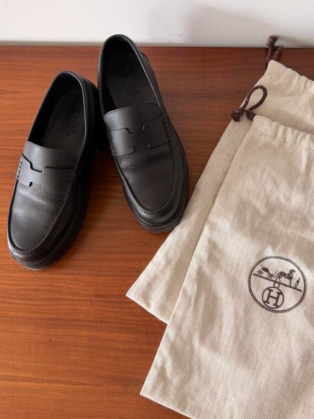 Hermès Klement black leather platform loafers with H logo.
